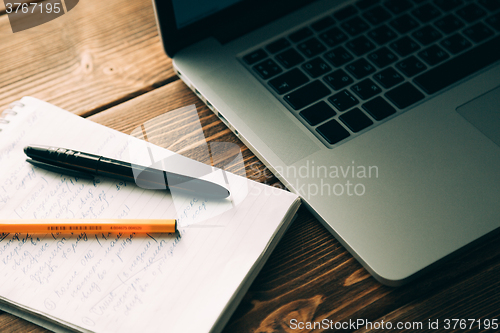 Image of Workplace with open laptop on modern wooden desk 