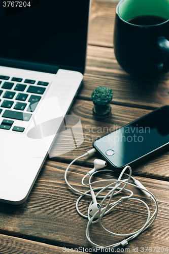 Image of Workplace with open laptop on modern wooden desk 