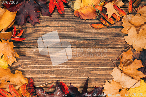 Image of Background with wooden table and autumnal leaves
