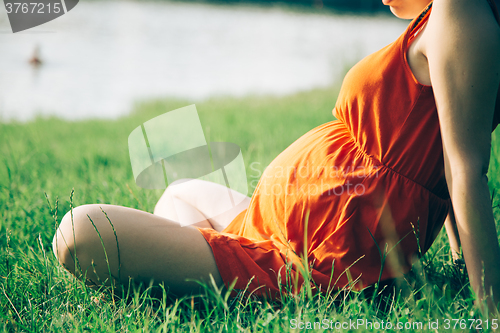 Image of Pregnant woman, holding in hands bouquet of daisy 