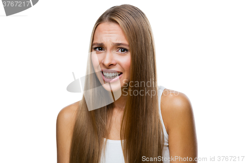 Image of Portrait of frowned woman on white background