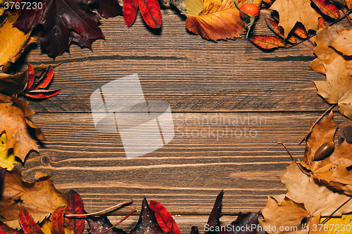 Image of Background with wooden table and autumnal leaves