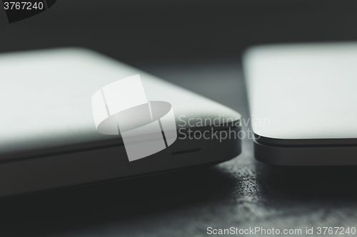 Image of Two closed laptops on modern wooden desk 