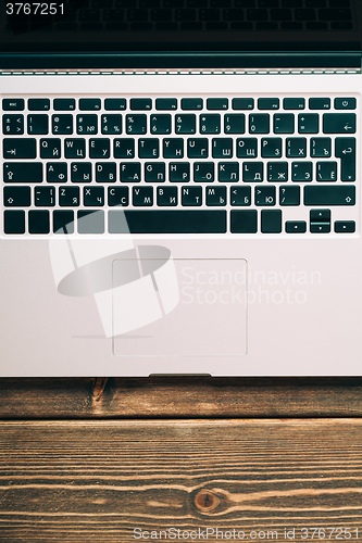 Image of Workplace with open laptop on modern wooden desk 