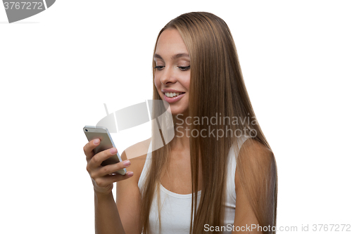 Image of Woman looks at the smartphone screen and smiles