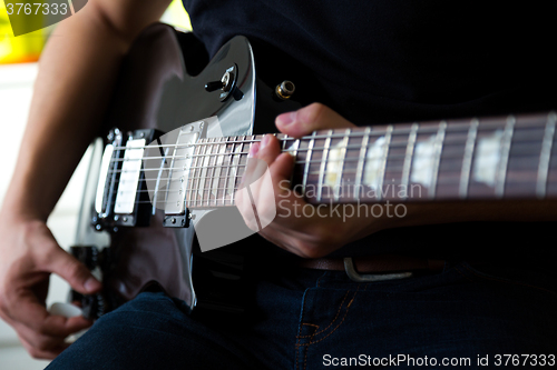 Image of Man playing on guitar