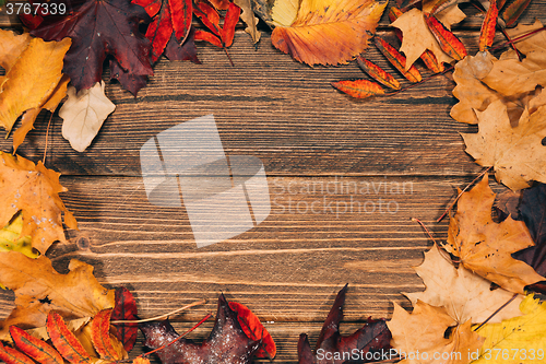 Image of Background with wooden table and autumnal leaves