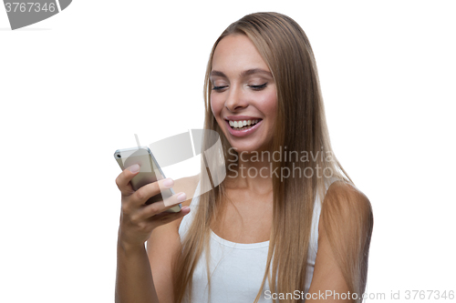 Image of Woman looks at the smartphone screen and smiles