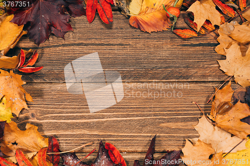 Image of Background with wooden table and autumnal leaves