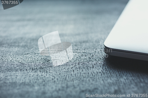 Image of Closed aptop on modern wooden desk 