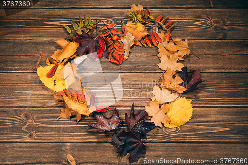 Image of Background with wooden table and autumnal leaves