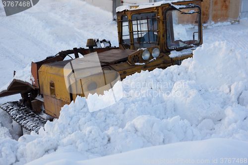 Image of Tractor with scraper removes snow