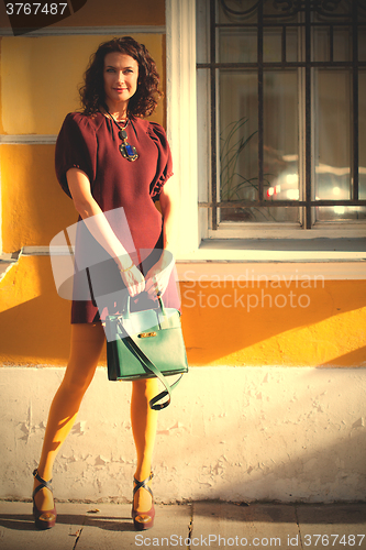 Image of beautiful middle-aged woman in a burgundy dress