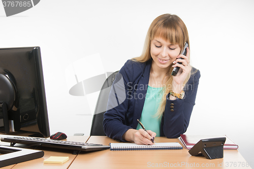 Image of Business woman talking on the phone records in a notebook date business meeting