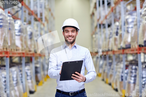 Image of happy businessman with clipboard at warehouse