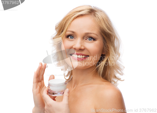 Image of happy woman applying cream to her face