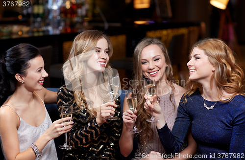 Image of happy women with champagne glasses at night club