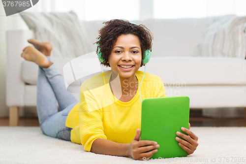 Image of happy african woman with tablet pc and headphones