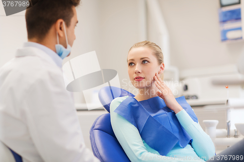 Image of male dentist with woman patient at clinic