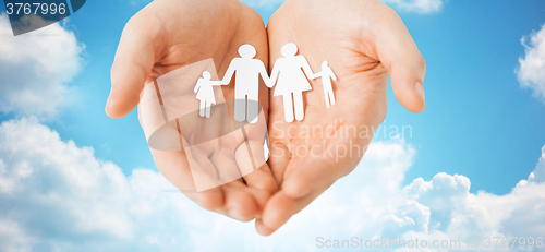 Image of man hands holding paper cutout of family