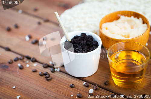 Image of close up of coffee scrub in cup and honey on wood