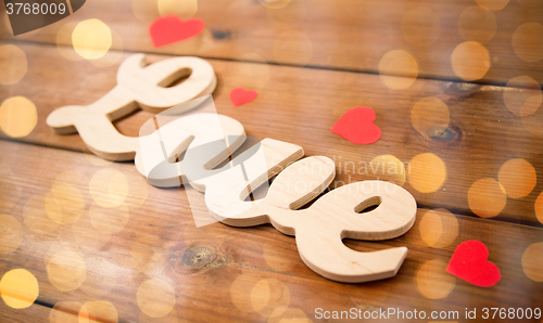 Image of close up of word love with red paper hearts