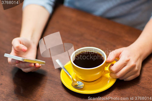 Image of close up of woman with smartphone and coffee