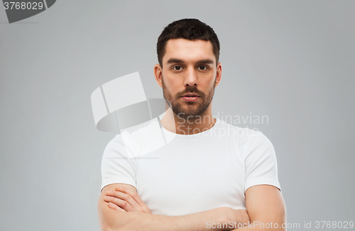 Image of young man with crossed arms over gray background