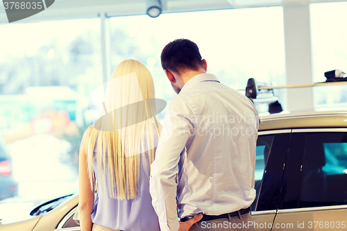 Image of couple buying car in auto show or salon