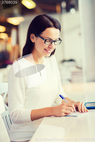 Image of smiling woman with tablet pc at cafe