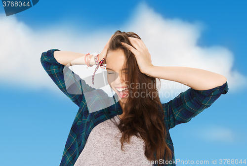 Image of happy pretty teenage girl holding to head