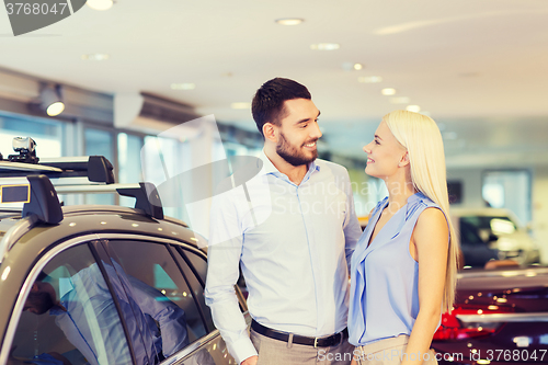 Image of happy couple buying car in auto show or salon