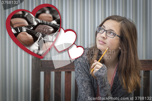 Image of Daydreaming Girl Next To Floating Hearts with Chocolates