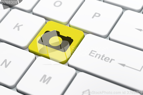 Image of Vacation concept: Photo Camera on computer keyboard background