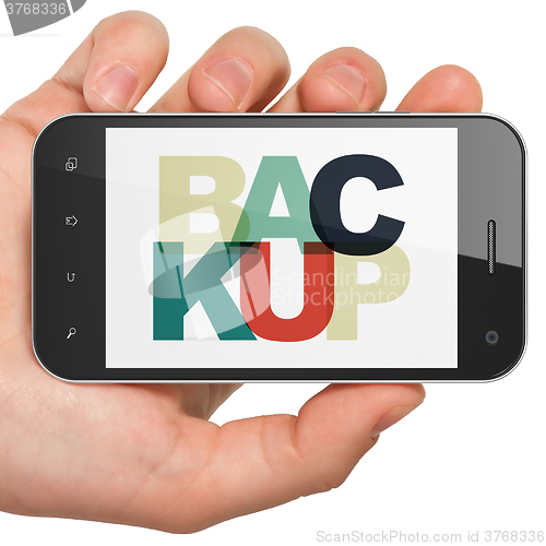 Image of Software concept: Hand Holding Smartphone with Backup on  display