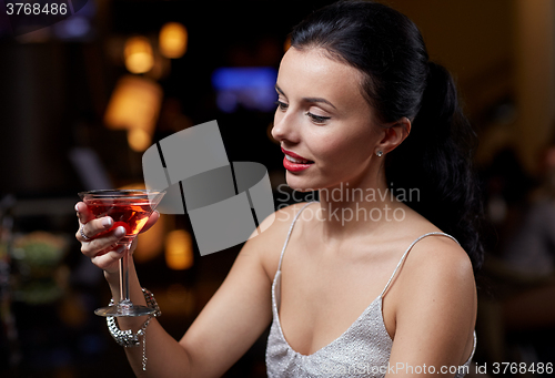 Image of glamorous woman with cocktail at night club or bar