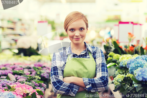 Image of happy woman with flowers in greenhouse