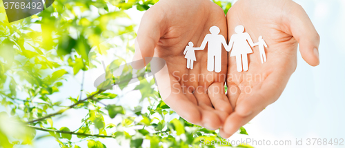 Image of man hands holding paper cutout of family