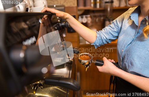 Image of close up of woman making coffee by machine at cafe