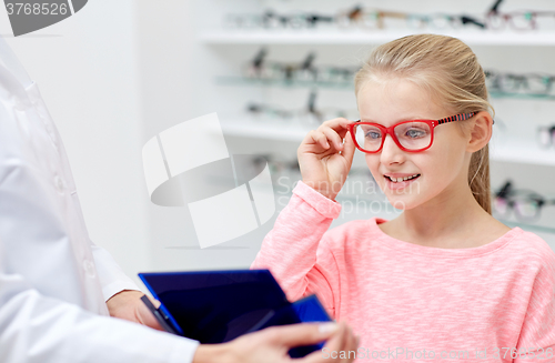 Image of optician and girl choosing glasses at optics store