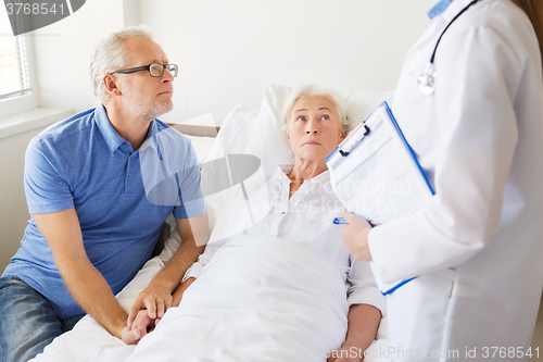 Image of senior woman and doctor with clipboard at hospital