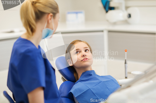 Image of happy female dentist with patient girl at clinic