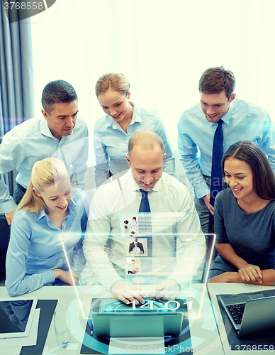 Image of smiling business people with laptop in office