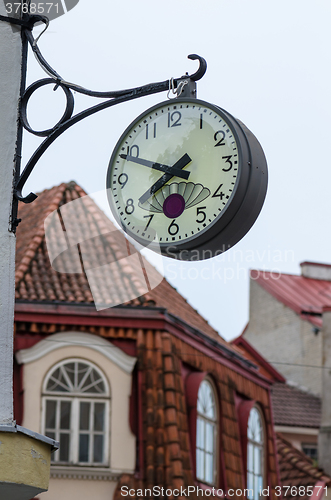 Image of The town clock on the background of tiled roofs of Tallinn, clos