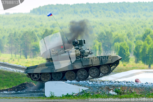 Image of Tank T-80 overcomes a high concrete obstacle