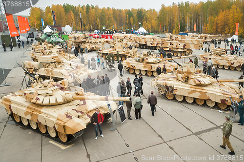 Image of Visitors explore military vehicles on exhibition