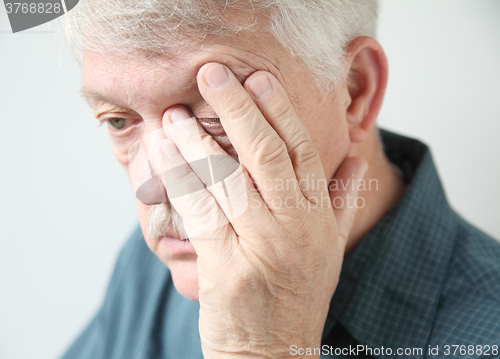 Image of Tired man rubbing his eye