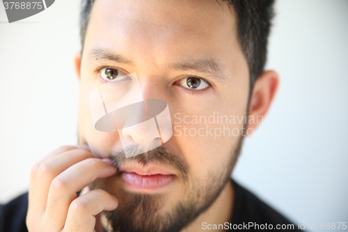 Image of Young man scratching his beard