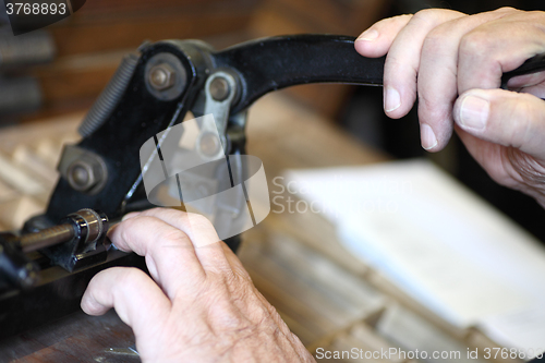 Image of Letterpress printer cutting metal slugs