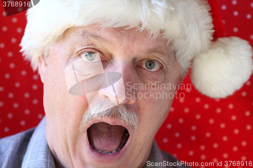 Image of Santa hat on man looking alarmed